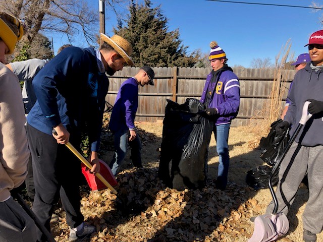 The DC3 Baseball team and volunteers rake leaves during the RSVP Annual Clean-Up Day